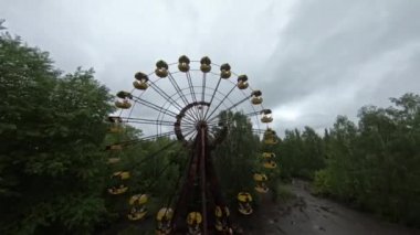 FPV dron görüntüsü. Terk edilmiş Pripyat kasabasında dönme dolabı olan bir lunaparka uçuş.