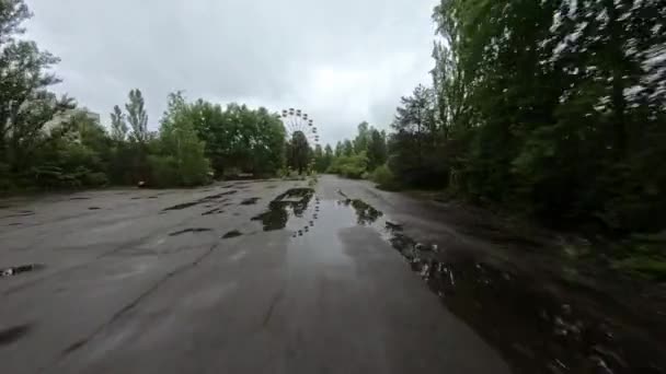 Vista de drones FPV. Voo para um parque de diversões com uma roda gigante na cidade abandonada de Pripyat — Vídeo de Stock