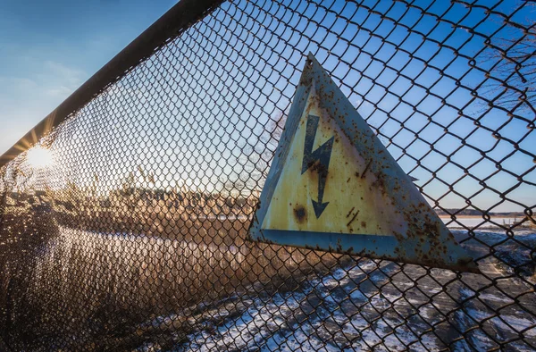 Yüksek gerilim çiti eski işareti kararsız güneş parlar