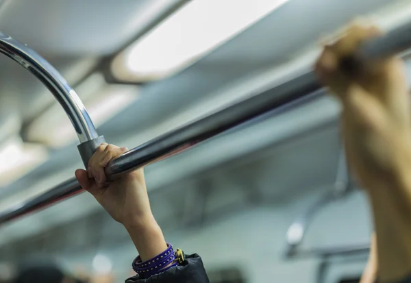 Gente sosteniendo la barandilla en la mano del metro en foco — Foto de Stock