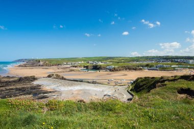 Çimenli bir tepeden geniş açı manzarası plajları, deniz havuzlarını, kayalıkları, kayaları, dalgaları ve yaz günlerinde Cornwall 'un kuzeyindeki Bude' deki tarlaları gösteriyor..