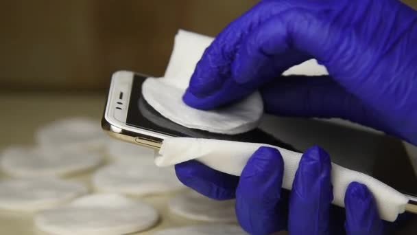 一个戴医疗手套的男人擦拭他的手机 倒入抗病毒液 清洁液 — 图库视频影像
