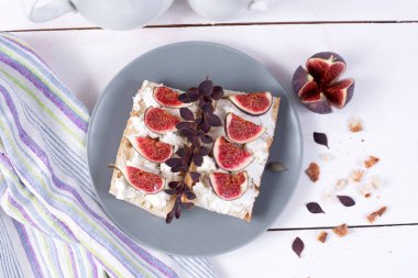 İncirli sandviç, tabakta ricotta ve beyaz ahşap masa..