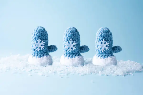 Tiga Sarung Tangan Biru Merajut Salju Pada Latar Belakang Biru — Stok Foto