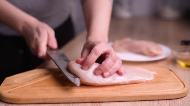 Womans hands with a knife slice a delicate chicken fillet. — Stock Video