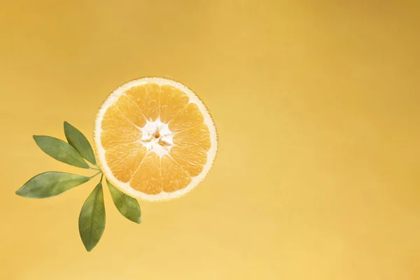Potongan Oranye Segar Dengan Daun Hijau Pada Latar Belakang Kuning — Stok Foto