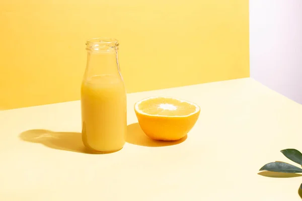 Sebuah Botol Dengan Jus Jeruk Dan Setengah Jeruk Pada Latar — Stok Foto