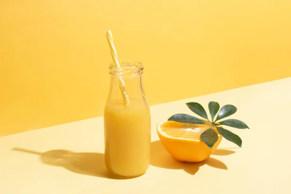 Sebuah Botol Dengan Jus Jeruk Dan Setengah Jeruk Dan Jerami — Stok Foto