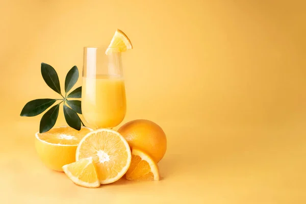 Glas Mit Frischem Orangensaft Und Halbierten Orangen Auf Gelbem Hintergrund lizenzfreie Stockfotos