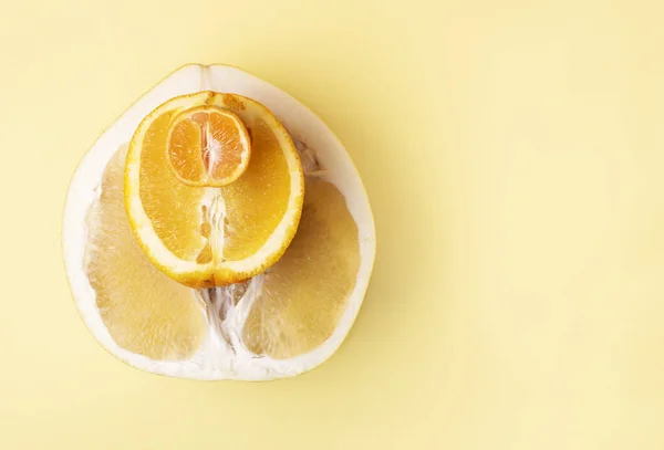 Sulu taze zeytinlerin yarısı, turuncu ve mandalina üst üste sarı arka planda, yakın plan, kopyalama alanı. Citrus meyveleri.