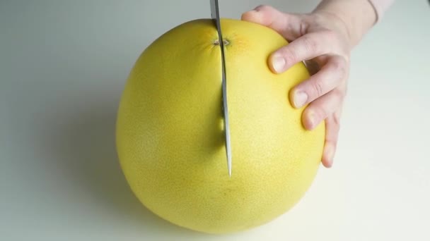Samice ręce cięcia na pół duże owoce cytrusowe pomelo — Wideo stockowe
