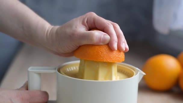 Жіноча рука стискає сік з органічних апельсинів на соковижималку — стокове відео