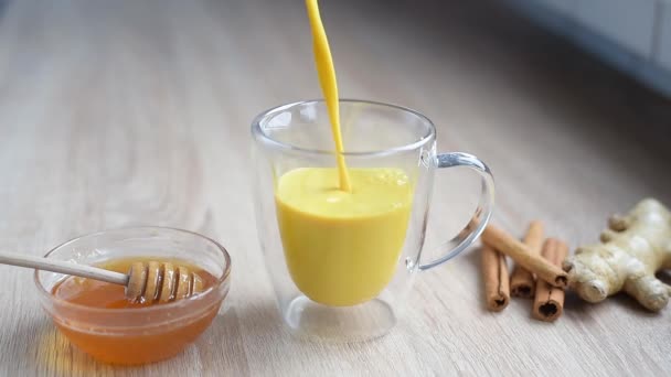 Kurkuma tejet, aranytejet öntenek egy csészébe a konyhában.. — Stock videók