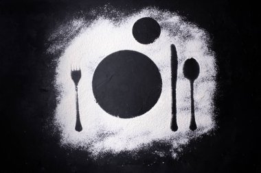 Buğday unundaki çatal bıçak izleri, servis tabağı izleri, siyah arka plan, kapat..