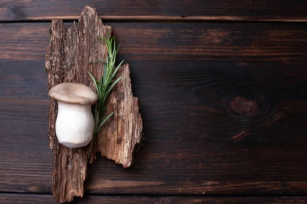 Bir kral istiridye mantarı ahşap bir arka planda biberiye filizi ile kırsal tarzda, yakın çekim.