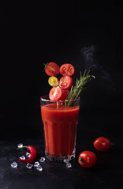 Domatesli Bloody Mary, siyah arka planda biberiye ve kırmızı biber, domates suyuyla alkollü kokteyl, kapat..
