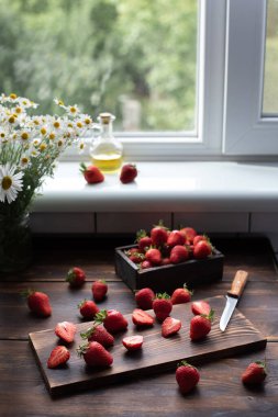 Mutfaktaki ahşap masa üzerinde çilek, bir buket papatya ve tekstil, ev yapımı sağlıklı yiyecekler, yaz konsepti, kapat..