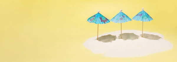 Pulau Sandy Dengan Tiga Payung Biru Dengan Latar Belakang Kuning — Stok Foto
