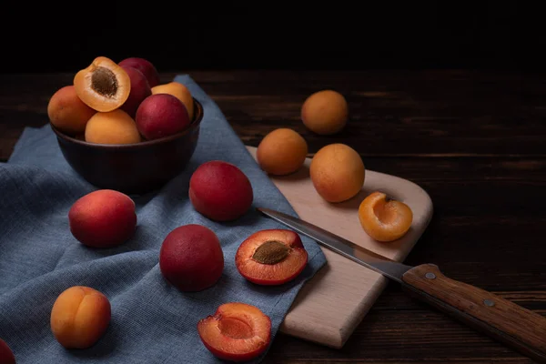 Masaya dağılmış kırmızı kayısılar mavi tekstil ile koyu renkli, kırsal tarzda, kapat..