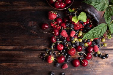 Ahududu, çilek, kiraz, frenk üzümü, sağlıklı yiyecekler, koyu ahşap masaya saçılmış, yaz meyveleri, yakın plan..