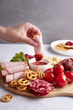 Aperatifli tabaklar, sosa batırılmış bir dilim jambon sosa sosis, sosis, peynir, kraker ve meyve, yakın plan..