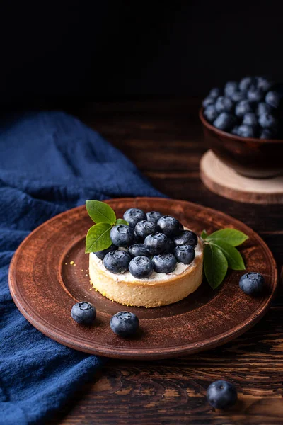 Böğürtlenli tatlı, koyu ahşap arka planda yabanmersinli tart, yaz tatlı yemeği..