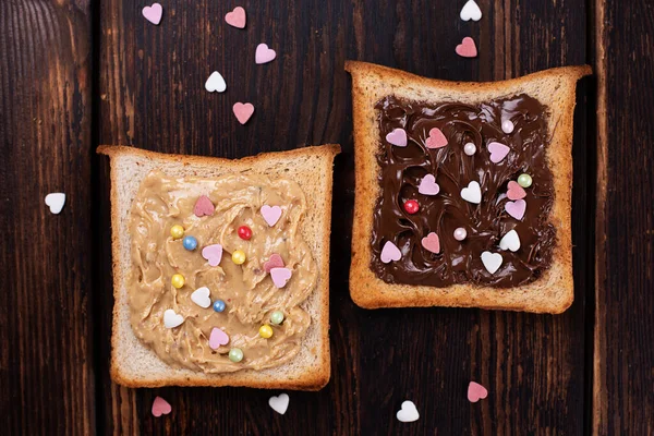 Manteiga Amendoim Pasta Chocolate Torradas Polvilhadas Com Corações Coloridos Fundo — Fotografia de Stock