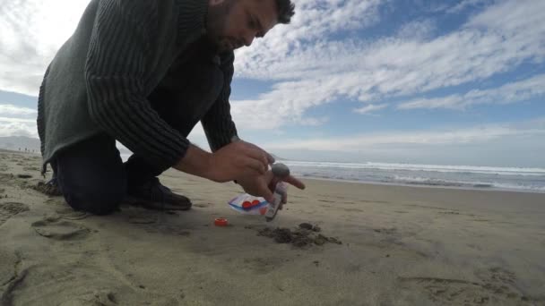 Veldwetenschapper monsterneming zand op een strand — Stockvideo