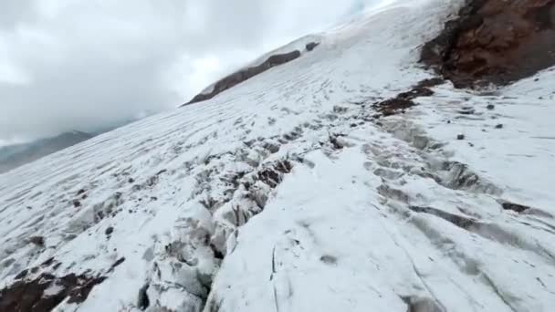 Movimiento aéreo a lo largo de pintorescas laderas nevadas del viejo Elbrus en el deporte fpv drone — Vídeos de Stock