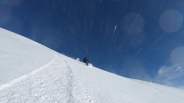 Snowboarder człowiek jazda na snowboardzie na puszystym śniegu w zimie góry. — Wideo stockowe