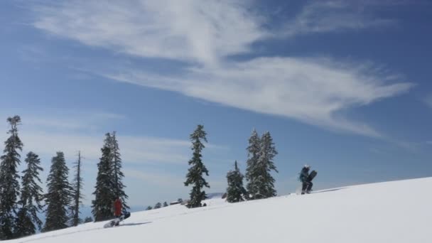 Snowboardåkare med snowboard klättring i snöiga berg med fantastiskt hav — Stockvideo