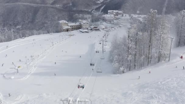 Mensen rijden op ski en snowboard in het bergresort. Luchtzicht — Stockvideo