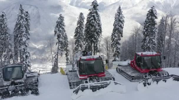 Snowcat standing on parking lot in snowy mountain at winter ski resort — Stock Video