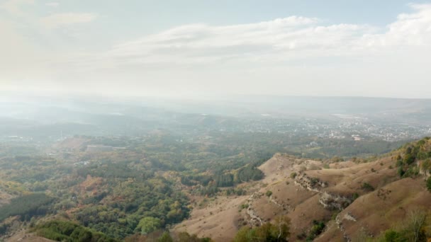 Biciclista viajante em bicicleta mtb de pé na borda da trilha da montanha na paisagem panorâmica. Montanha escalada e extrema bicicleta enduro viagem. Bela cidade no vale da montanha de drone aéreo acima. — Vídeo de Stock