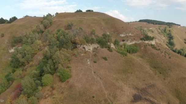 Declive rochoso na montanha de drone acima. Colinas e planaltos na vista aérea da montanha. Pessoas turísticas caminhando no cume das terras altas enquanto caminhadas de verão. Kislovodsk, sela pequena — Vídeo de Stock