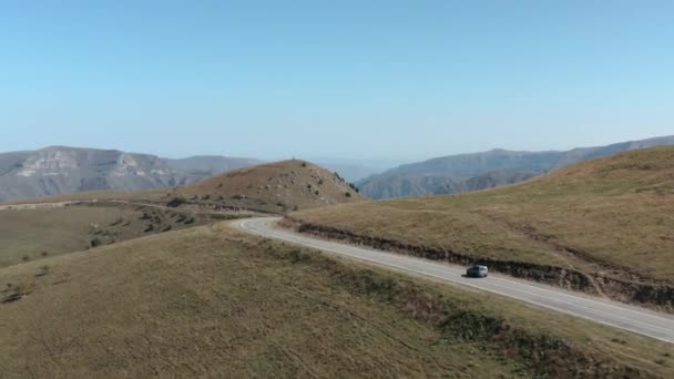 Oszałamiająca sceneria z drona krętej drogi w górach wśród wzgórz. Podróż samochodem w Kabardino-Balkaria. Krajobrazy Elbrus z lotu ptaka. — Wideo stockowe
