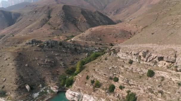山脚上的岩石高地，来自上空的无人侦察机。游客们乘坐越野车在蜿蜒的山路上旅行.Kabardino Balkaria的Bylym地区和Gizhgit湖. — 图库视频影像
