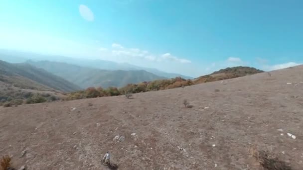 Fpv cinemático tiro motociclista equitação e-bike na encosta trilha highland na paisagem da montanha. Bicicleta mtb piloto de treinamento em bicicleta elétrica em terreno de montanha vista aérea. Viagem de montanha extrema. — Vídeo de Stock