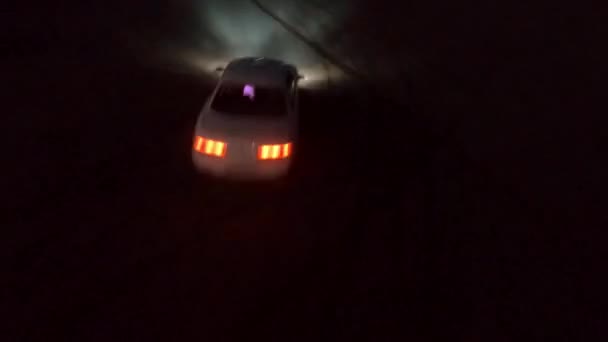 Carro esporte à deriva na estrada de asfalto na cidade noturna tiro aéreo. Fpv freestyle drone vista jdm branco corridas de veículos passeios à deriva de corrida noturna com fumaça de pneus — Vídeo de Stock