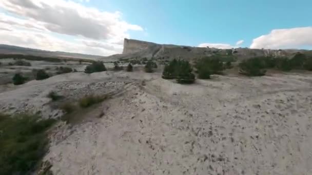 Fpv esporte drone tiro cinematográfico rápido. Grande vale com pinheiros raros e penhasco branco íngreme sob o céu com nuvens brancas no dia ensolarado perto drone primeira vista aérea ponto — Vídeo de Stock