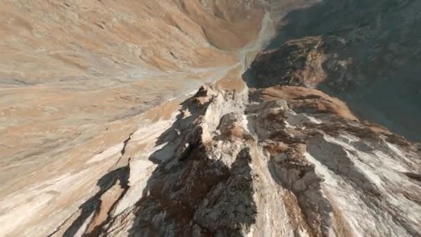 Snabb extrem nära dykning släppa ner flyga branta steniga berg bergstopp sluttningar och pittoreska sten kanjon med smal slingrande bäck på solig dag fpv racing drönare första punkten antenn cinematic vy — Stockvideo