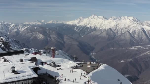 Shooting from helicopter people enjoying leisure at mountain peak 2320 at winter season. Aerial panning around view man woman and kids walking contemplating amazing alpine scenery at ski resort — Stock Video