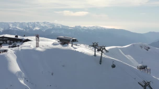 Vista aérea del dron panorámico desde arriba escenografía estación de esquí alpino con cabina de teleférico y gente relajante turística. Increíble invierno nevado paisaje natural en el centro recreativo extremo pico de montaña 2320 — Vídeo de stock