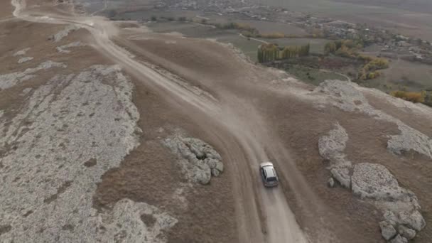 Tiro de drone velocidade movimento suv automóvel em White Cliff perto do abismo na bela paisagem da natureza. Vista aérea rápido equitação no pico de formação de montanha cercado por paisagem de vale e céu — Vídeo de Stock