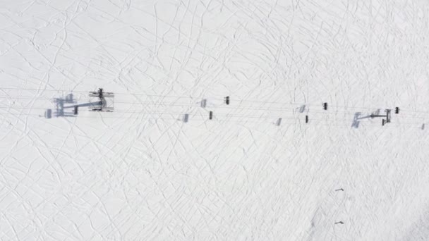 Vista aérea superior desde arriba telesilla que se mueve por cable en la estación de esquí en invierno. telesilla elevador de esquí para el transporte esquiadores y snowboarders en invierno nieve montaña estación 4k — Vídeos de Stock