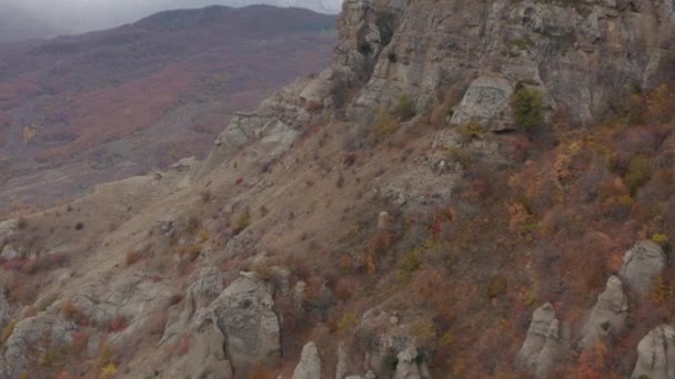 Vallée des fantômes falaise Demerdji et des roches dans les hautes terres parmi la forêt d'automne avec des arbres colorés de drone aérien ci-dessus. Roches et montagnes envoûtantes sur le paysage des prairies 4k — Video