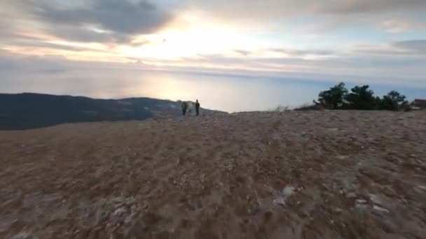Aerial tiro grupo mochileiros de pé no topo da montanha Ai petri vale natural com mar ao pôr do sol — Vídeo de Stock