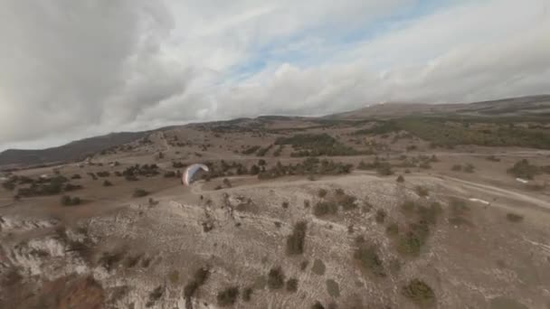 Actief koppel vliegend op paraglider over de natuur zeegezicht met bewolkte hemel bij zonsopgang luchtfoto — Stockvideo