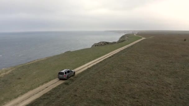 Rastreamento aéreo tiro de alta velocidade suv automóvel dirigindo no topo da estrada da montanha paisagem marinha céu natural — Vídeo de Stock