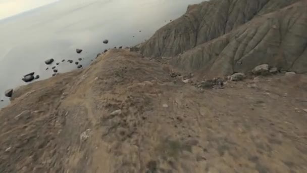 Luchtfoto vliegende natuurlijke hoge klif berg omgeven door de kust met mist fpv sport drone — Stockvideo